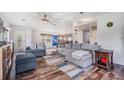 Bright living room featuring wood floors, a plush gray sofa, and lots of natural light at 7011 Tall Pine Rd, Polk City, FL 33868
