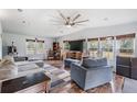 Inviting living room with wood floors, a large sectional sofa, and plenty of natural light at 7011 Tall Pine Rd, Polk City, FL 33868