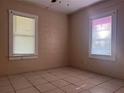 A cozy bedroom is enhanced by windows and tile floors that provide natural light and a clean space at 711 E Valencia St, Lakeland, FL 33805