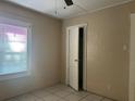 Bedroom featuring an open closet with window, tile flooring and ceiling fan at 711 E Valencia St, Lakeland, FL 33805