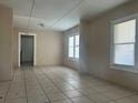 Bright living room features tile flooring, light-colored walls, and natural light from multiple windows at 711 E Valencia St, Lakeland, FL 33805
