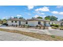 Spacious single-story home featuring a large concrete driveway, manicured lawn, and decorative landscaping at 1433 Ellison Ln, Lakeland, FL 33801