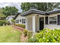 Inviting front porch featuring a stylish black front door, manicured shrubs, and black accent shutters at 1536 Del Crest Pl, Lakeland, FL 33803