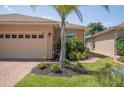 Home exterior featuring a manicured lawn, tropical landscaping, and a brick-paved walkway at 1620 Linz Ct, Winter Haven, FL 33884