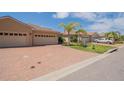 Exterior shot featuring a long driveway and beige-colored residences with tropical landscaping at 1620 Linz Ct, Winter Haven, FL 33884