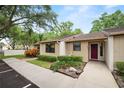 Inviting home showcasing well-maintained landscaping and a red front door, adding a touch of warmth and character at 2025 Sylvester Rd # E2, Lakeland, FL 33803