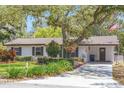 Charming home with well-manicured lawn, mature trees and flowering bushes at 209 S Hydrangea Ave, Polk City, FL 33868
