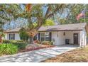 Traditional home featuring mature trees, landscaping, and a welcoming front exterior at 209 S Hydrangea Ave, Polk City, FL 33868