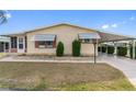 Inviting single-story home featuring a covered parking area and well-maintained landscaping at 211 Sweet Cir, Winter Haven, FL 33884
