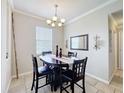 A dining room displays a dark wood table and chairs, neutral walls, and a modern chandelier, creating an inviting ambiance at 2112 Betsy Ross Ln, St Cloud, FL 34769