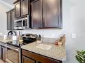 The kitchen features granite countertops, stainless steel appliances and dark cabinets for a modern look at 2112 Betsy Ross Ln, St Cloud, FL 34769