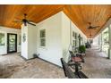 Expansive covered porch with ceiling fans, rocking chairs, and brick flooring at 2115 W Pipkin Rd, Lakeland, FL 33811