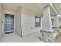Welcoming front porch with stylish columns, stone accents, and a charming 'Casa es mi casa' sign at 2611 San Marco Way, Winter Haven, FL 33884