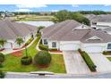 Aerial view showcasing a home with a well-manicured lawn, landscaping, and a nearby pond at 2820 Prestwick Dr, Lakeland, FL 33803