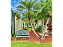 Inviting exterior features a bench seat, lush palm trees, and colorful foliage at 2820 Prestwick Dr, Lakeland, FL 33803