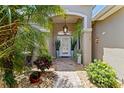 Inviting front entrance with lush greenery, decorative plants and hanging decorative outdoor lighting at 3187 Bellflower Way, Lakeland, FL 33811