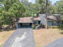 Charming single Gathering home featuring a two-car carport, mature landscaping, and a welcoming walkway to the front door at 319 Shadow Moss Ct # 319, Lakeland, FL 33813