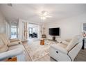 Bright living room with comfortable seating, a ceiling fan, and sliding doors leading to a cozy home office at 319 Shadow Moss Ct # 319, Lakeland, FL 33813