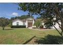 Charming single-story home with lush landscaping and a well-manicured lawn, partially shaded by a tree at 3359 Sanoma Dr, Lakeland, FL 33811