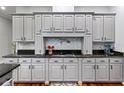 Stylish kitchen features light gray cabinets, dark countertops, a pot filler, and mosaic backsplash at 3812 Cheverly E Dr, Lakeland, FL 33813