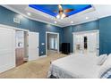 Spacious main bedroom with stylish tray ceiling lighting, neutral carpet, and access to ensuite bathroom at 3812 Cheverly E Dr, Lakeland, FL 33813