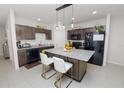 Well-lit kitchen showcasing stainless steel appliances, granite countertops, and a convenient island with seating at 3857 Hampstead Ln, Lakeland, FL 33810
