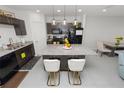 Bright kitchen boasting granite countertops, dark cabinetry, and a functional center island with bar stools at 3857 Hampstead Ln, Lakeland, FL 33810