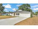 Beautifully renovated, white brick home with a modern garage and long driveway provides ample parking at 4028 S Wellington Dr, Lakeland, FL 33813
