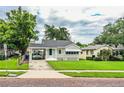 Charming one-story home with carport, manicured lawn and mature tree offering ample shade at 422 E Belmar St, Lakeland, FL 33803
