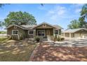Inviting home exterior featuring a brick path, lush landscaping, and a detached garage, combining charm and functionality at 5201 Dorman Rd, Lakeland, FL 33813