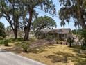 Beautiful home with mature trees, manicured lawn, and a welcoming brick path enhancing its curb appeal at 5201 Dorman Rd, Lakeland, FL 33813