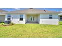Backyard with green grass and a covered patio that includes glass paneled doors at 535 Tanaro Ln, Haines City, FL 33844