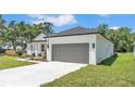 Exterior angled view of a single-story home with a gray roof, gray garage door, and landscaped front yard at 5508 Odom, Lakeland, FL 33809