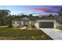Charming single-story home with a gray roof, gray garage door, landscaped front yard, and inviting entrance at 5508 Odom, Lakeland, FL 33809