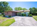 Inviting single-story home with an attached garage and lush green surroundings at 6529 Farris Dr, Lakeland, FL 33811