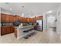 Modern kitchen featuring stainless steel appliances, a breakfast bar island, and plenty of countertop space for cooking at 8929 Sugar Palm Rd, Kissimmee, FL 34747
