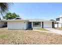 Charming single-story home with a light-colored exterior and a well-manicured lawn at 108 Sandburg Ln, Winter Haven, FL 33884