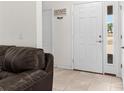 Bright foyer with white front door, side window, and a decorative welcome sign at 11 W Bay St, Davenport, FL 33837