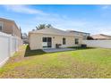 Spacious backyard with a well-kept lawn, white vinyl fence, and a patio area for outdoor enjoyment at 1216 Myopia Hunt Club Dr, Auburndale, FL 33823