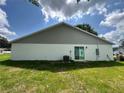 Exterior showcasing the siding, the backyard, and an air conditioning unit at 1253 Dosseywood Ln, Lakeland, FL 33811