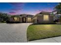Dusk view of the home's exterior showcasing its inviting curb appeal and landscaping details at 1295 Osprey Landing Dr, Lakeland, FL 33813