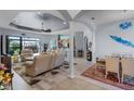 Spacious living room and dining area with columns, tile floors, and access to the patio at 1394 Oakmont Dr, Winter Haven, FL 33884