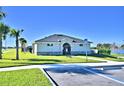 A modern clubhouse with well-manicured landscaping, clear blue sky and spacious sidewalks at 1517 Leamington Ln, Winter Haven, FL 33884
