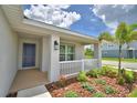 Inviting front porch with white railing, blue door, and manicured landscaping at 1517 Leamington Ln, Winter Haven, FL 33884