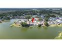 An aerial view of a home with a screened in back porch by the lake, surrounded by mature trees at 2015 Hatteras Pt, Lakeland, FL 33813