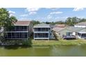 The home's backyard features a screened-in porch overlooking a lush green lawn and a serene lake at 2015 Hatteras Pt, Lakeland, FL 33813