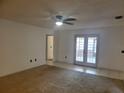Living room featuring carpet and tile flooring, a ceiling fan and access to the backyard at 2213 Eastmeadows Rd, Lakeland, FL 33812