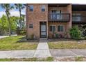 Charming brick condo with a cozy balcony, lush landscaping, and sidewalk leading to the front entrance at 2369 Tom Jones St # 8, Orlando, FL 32839