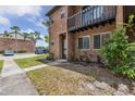 Image shows the exterior of a red brick condo, a charming balcony, and simple landscaping at 2369 Tom Jones St # 8, Orlando, FL 32839
