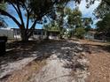 The backyard features overgrown areas mixed with sandy ground at 2610 Eaton Ave, Lakeland, FL 33803